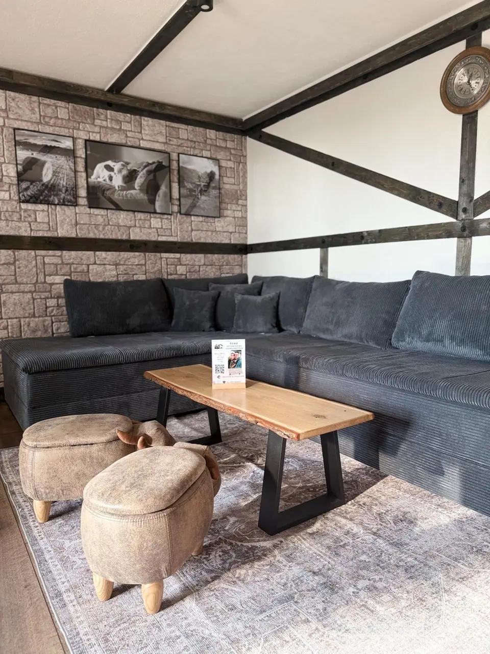 Cosy corner sofa with sheep stools beneath timber beams