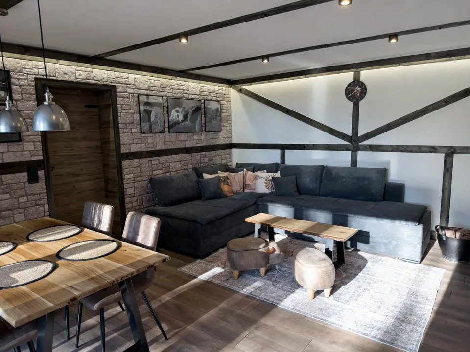 Living area with timber framing, corner sofa and dining table