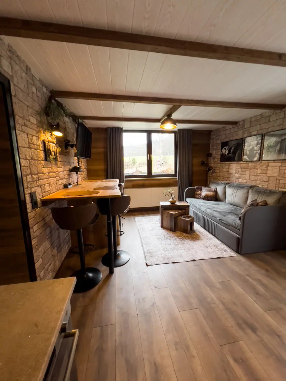 Living area with timber beams and stone wall