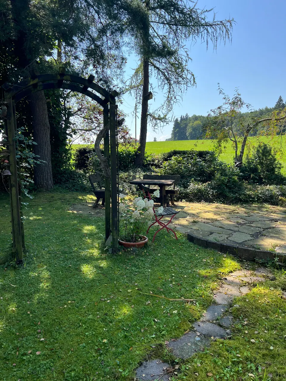 Weg unter der Pergola zur Natursteinterrasse