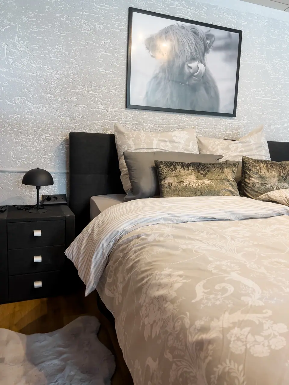 Doppelbett unter dem Bild eines Hochlandrinds